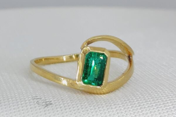 Anillo medio corazon con esmeralda
 rectangular al bisel