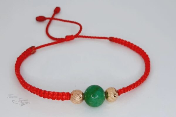 Pulsera tejida hilo rojo con  1 bolita esmeralda 1 bolitas diamantada oro amarillo y 1 bolita diamantada oro rojo